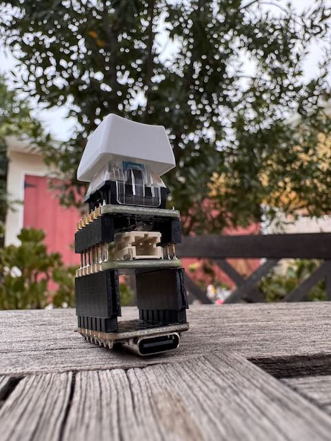 A small tower of three stories. The bottom level being the Xiao, which one can tell from the USB-C port, the middle one the battery BFF, and the top of the spire is a white key cap.