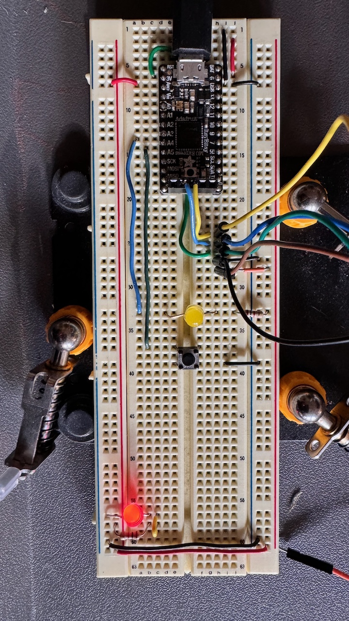 Photo of the ItsyBitsy on a breadabord with an LED and momentary switch